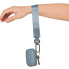 A hand is wearing a light blue nylon wrist strap keychain attached to a small pouch.