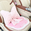 Pink bowknot car headrest pillow with lumbar support placed in a car seat.