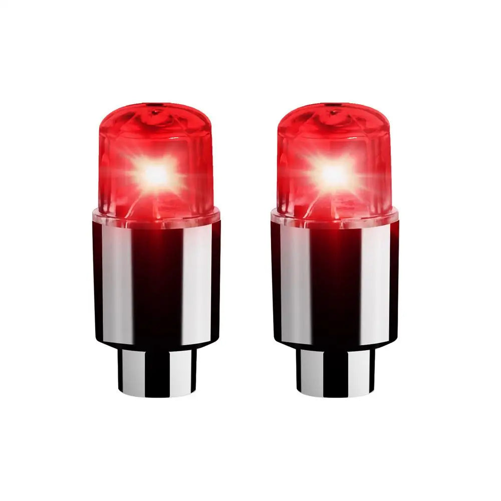 A pair of red LED tire valve stem lights with silver bases.