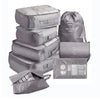 A set of gray mesh packing cubes and a drawstring bag for travel organization.