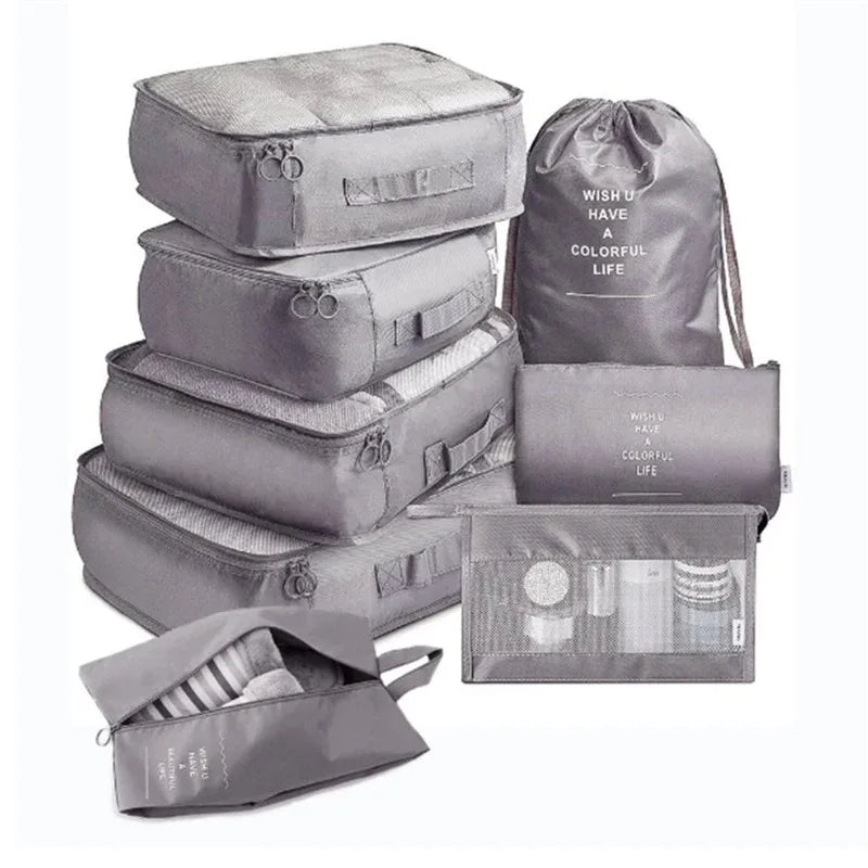 A set of gray mesh packing cubes and a drawstring bag for travel organization.
