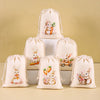 A set of six beige drawstring gift bags featuring illustrations of Easter bunnies and carrots.