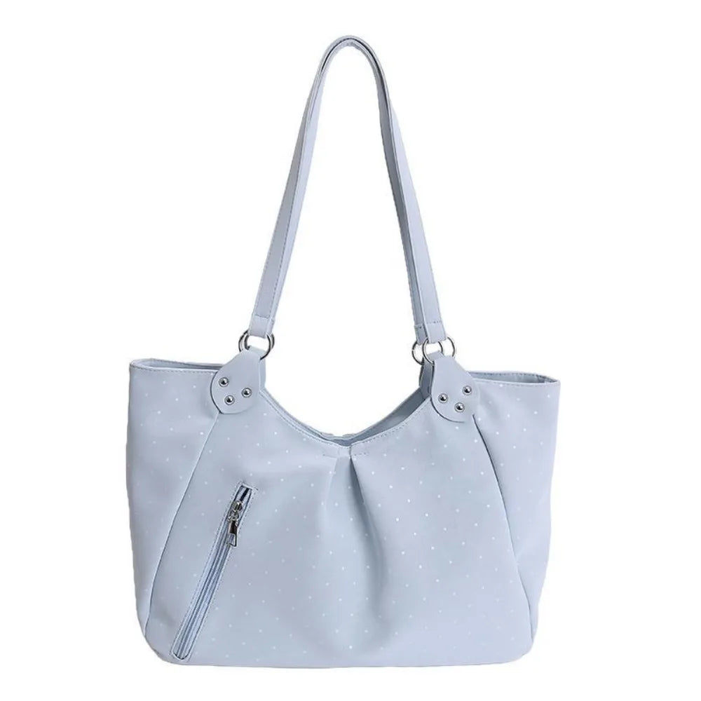 A light blue canvas tote bag with a slouchy shape and white polka dots.