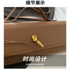 Close-up detail shot of a brown crocodile-embossed PU leather clutch bag showing the gold hardware and stitching.