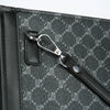 A close-up of a black textured leather handbag featuring a silver metal clasp and strap detail.