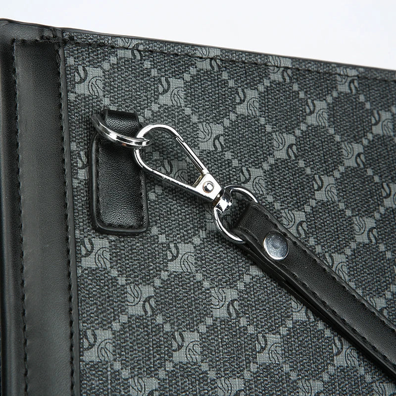 A close-up of a black textured leather handbag featuring a silver metal clasp and strap detail.