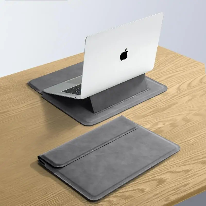 A silver laptop is placed inside a gray premium PU laptop sleeve on a wooden surface.