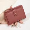 A hand holds a mauve pink ultra-thin PU leather card holder wallet with a zipper closure.