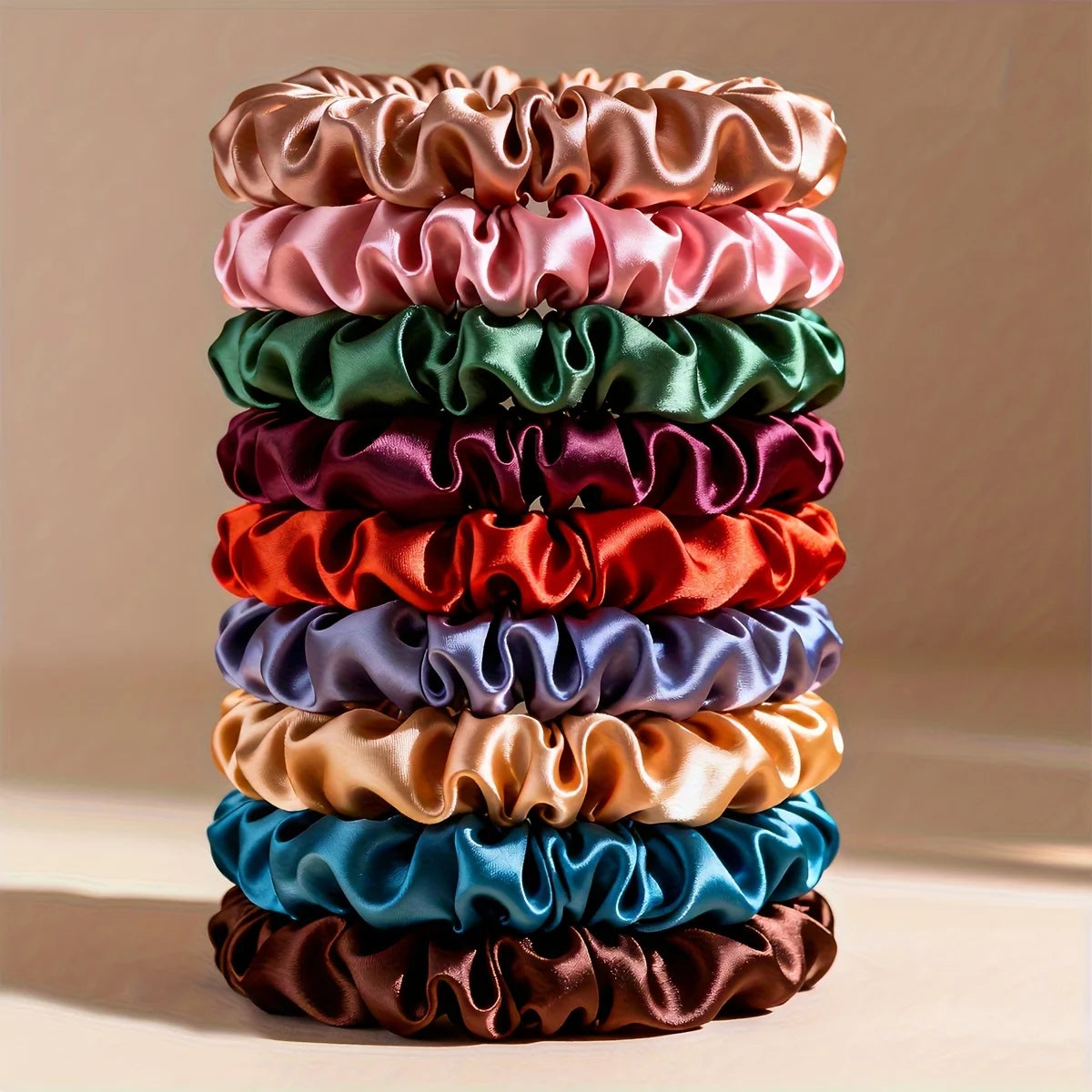 A stack of 19 thin scrunchies hair ties in various shades of pink, green, purple, and orange.