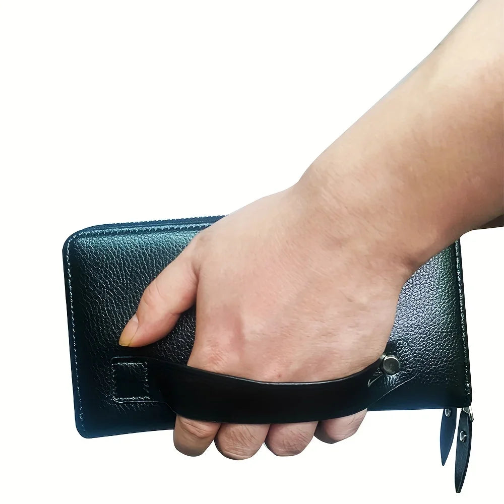 A hand is holding a black leather long zipper wallet clutch.