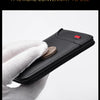 A hand holds a black lightweight and thin wallet with a coin inside, emphasizing quality and inessiveness.