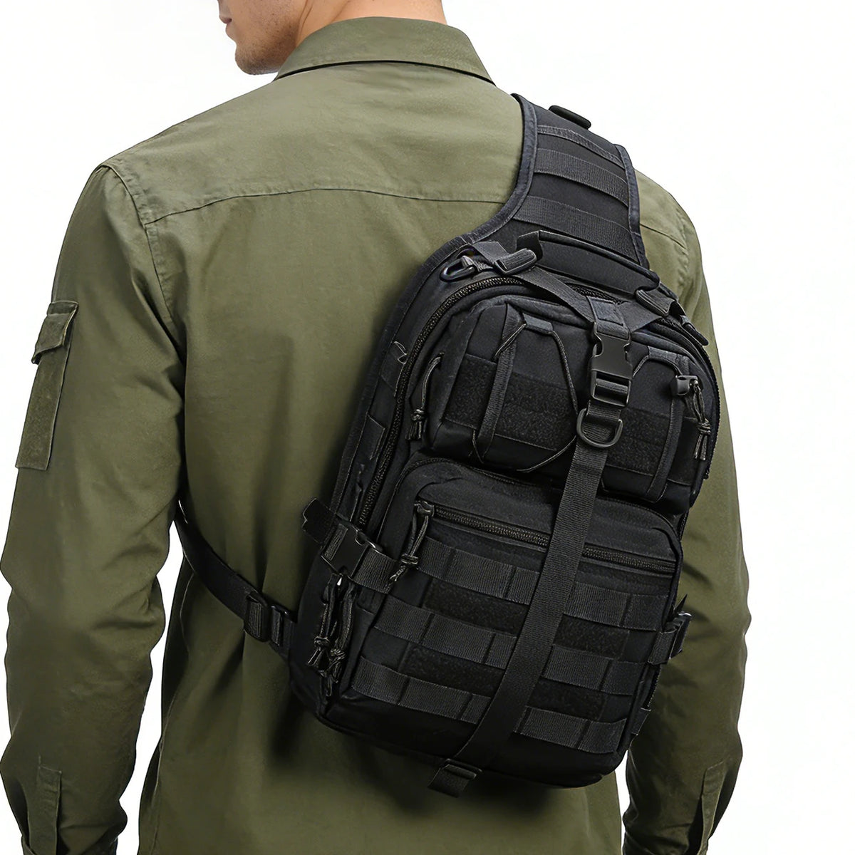 A person wearing a olive green shirt is holding a black multi-compartment crossbody and chest bag.