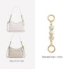 A white leather crossbody bag with a gold chain and a beige patterned version of the same bag.