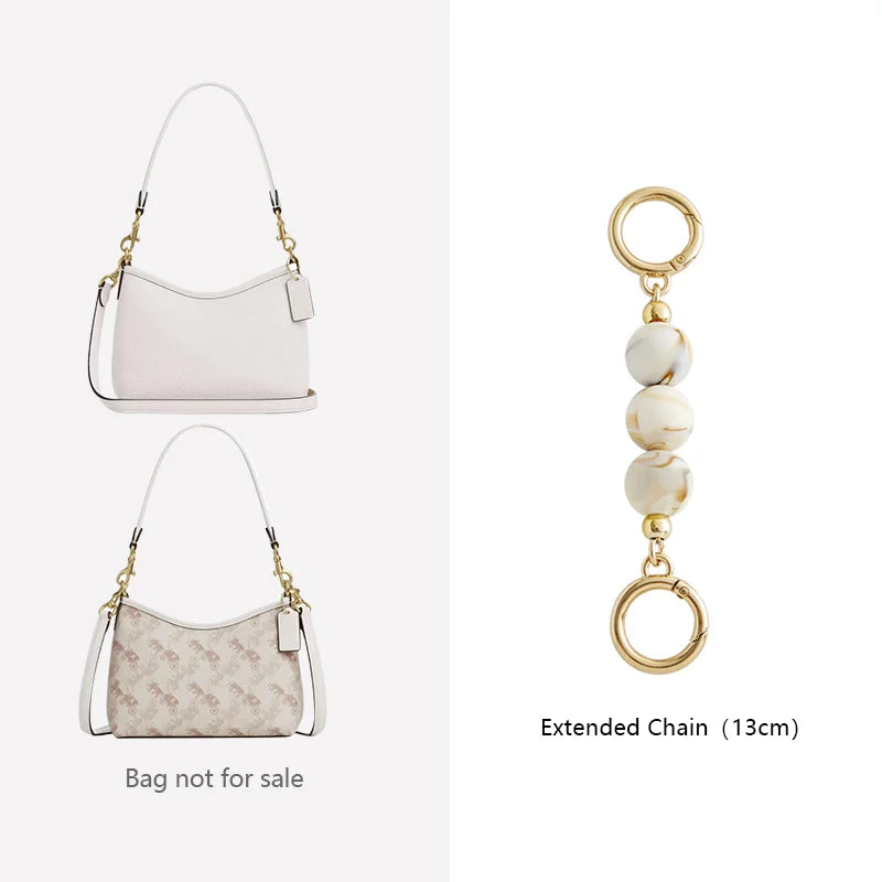 A white leather crossbody bag with a gold chain and a beige patterned version of the same bag.