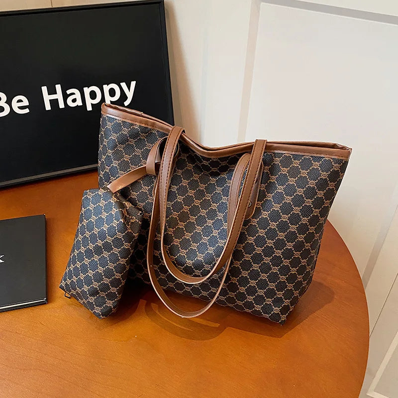 A brown geometric patterned tote bag with leather trim resting on a wooden surface.