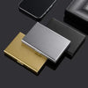 Un ensemble de porte-cartes métalliques fins en or et argent, présentés sur une surface sombre.