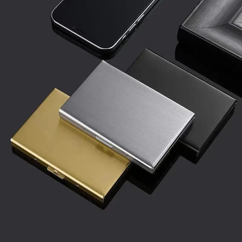 Un ensemble de porte-cartes métalliques fins en or et argent, présentés sur une surface sombre.