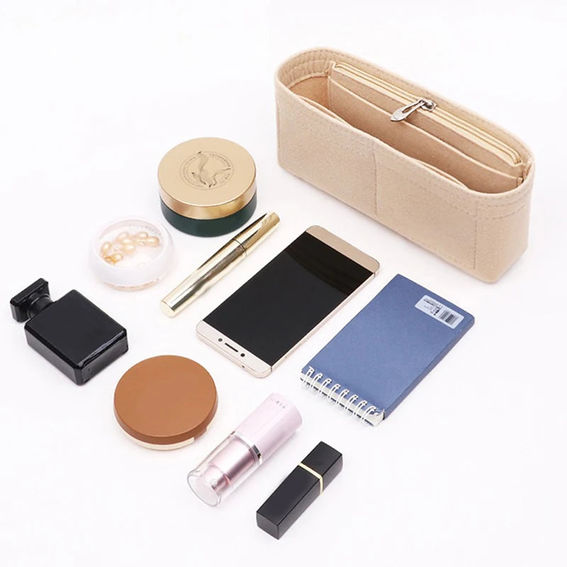 A collection of felt bag inserts and accessories including a zippered organizer, a pen, and a small notebook.