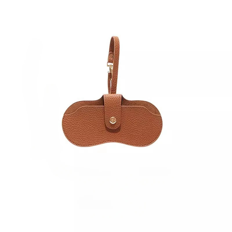 Una bolsa de cuero marrón con correa, diseñada para guardar gafas de sol delgadas.