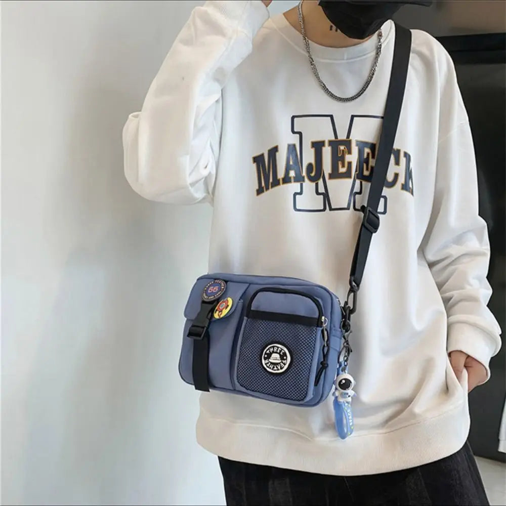 A person wearing a white sweatshirt holds a light blue canvas shoulder bag.