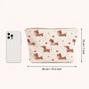 A beige cosmetic bag with a pattern of pink and brown dachshunds and hearts, shown next to an iPhone for scale.