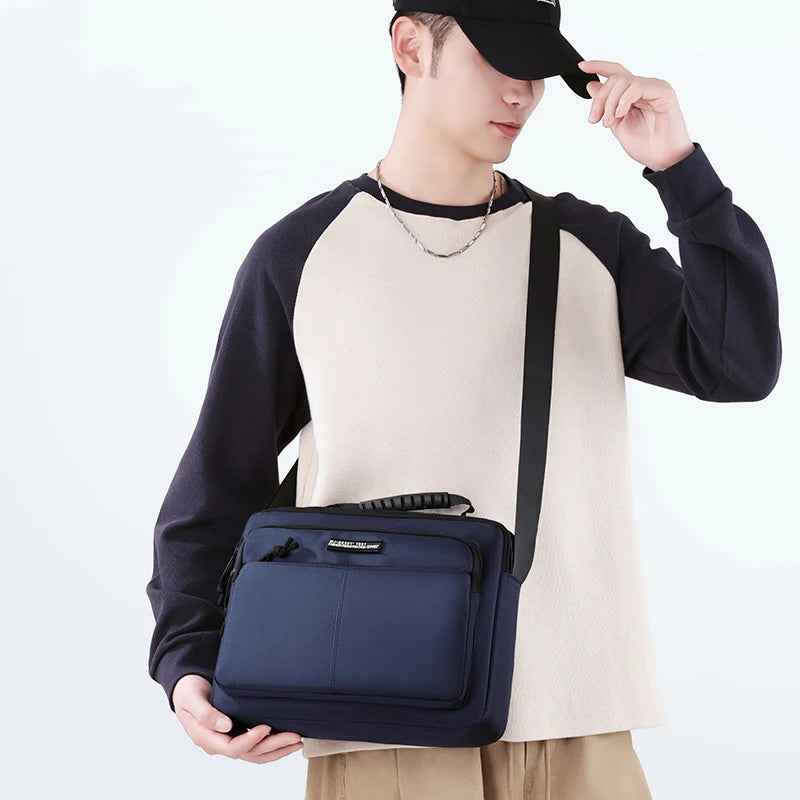 A man wearing a black cap and dark shirt holds a navy blue professional waterproof business briefcase.