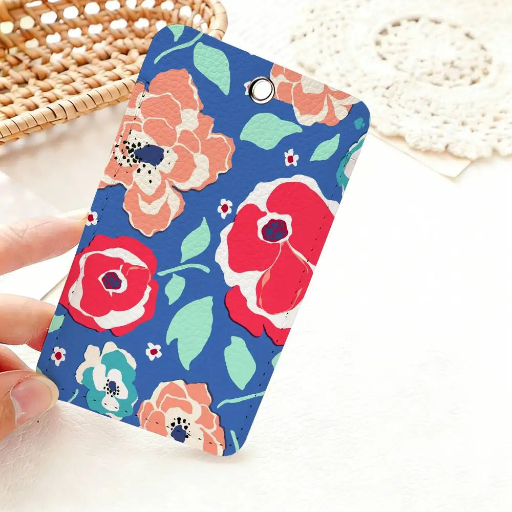 A hand holds a colorful floral design card holder with pink and red flowers on a blue background.