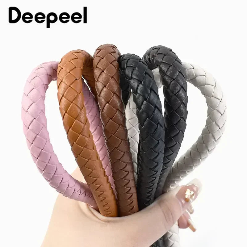 A set of interchangeable brown, pink, and black leather bag handles with metal buckles.