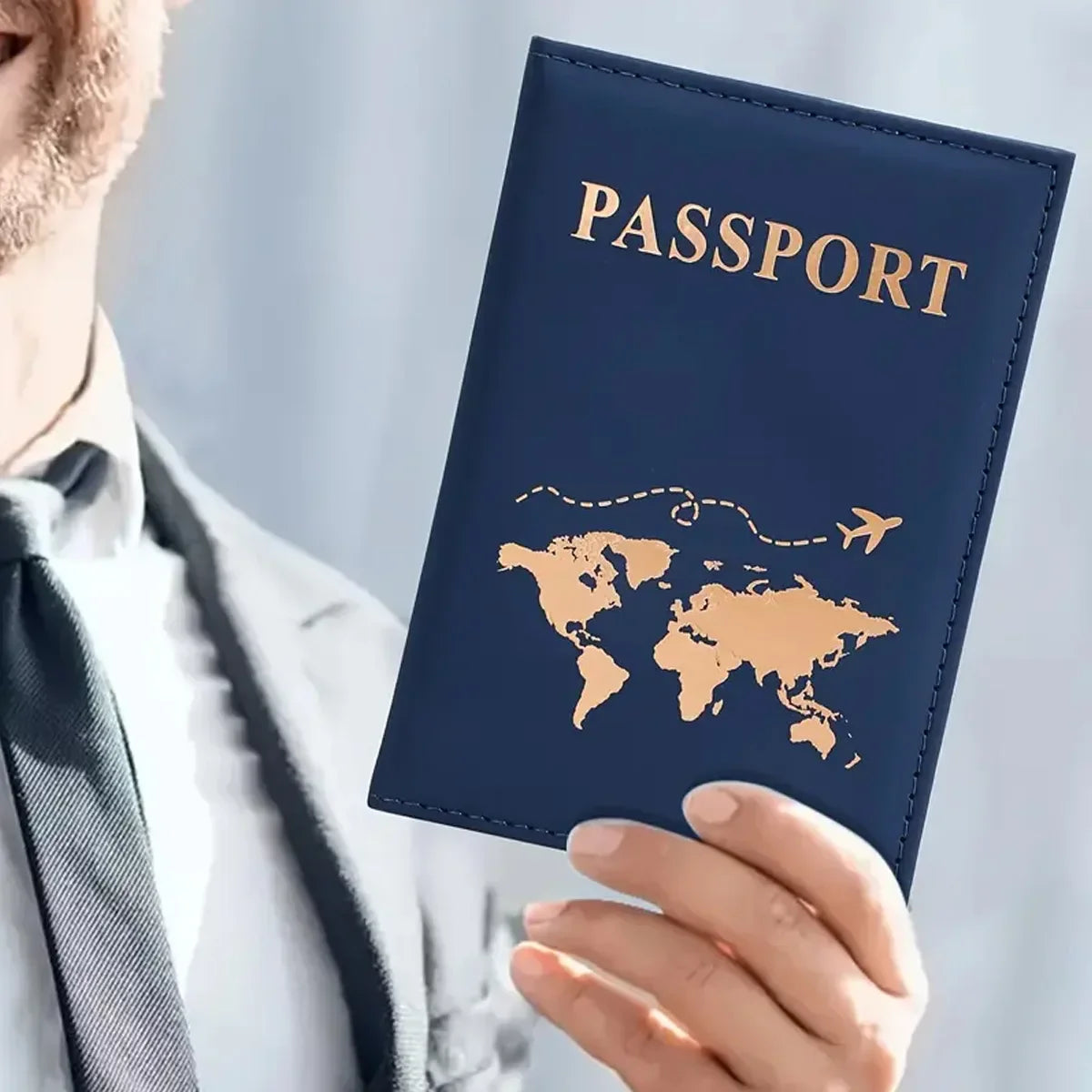Funda de pasaporte de cuero azul oscuro con estampado en foil dorado de un mapa mundial y la palabra PASAPORTE.