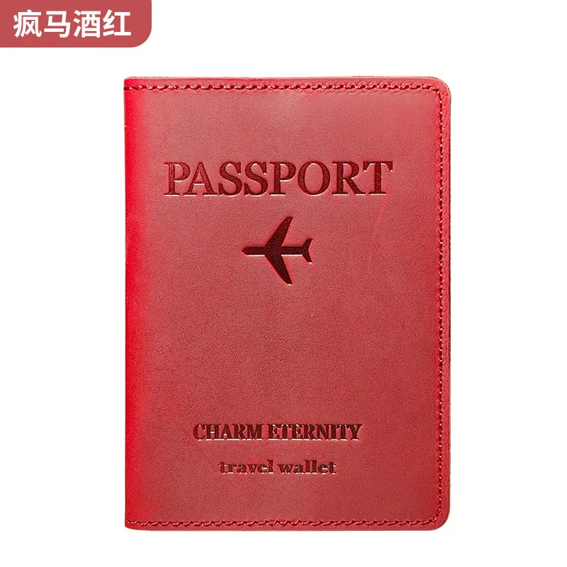 A red genuine leather passport holder and travel wallet with a silver airplane emblem.