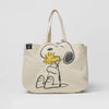A beige canvas shoulder bag featuring a Snoopy cartoon design.