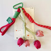 A set of red and green braided cord charms featuring tulip flower shapes.