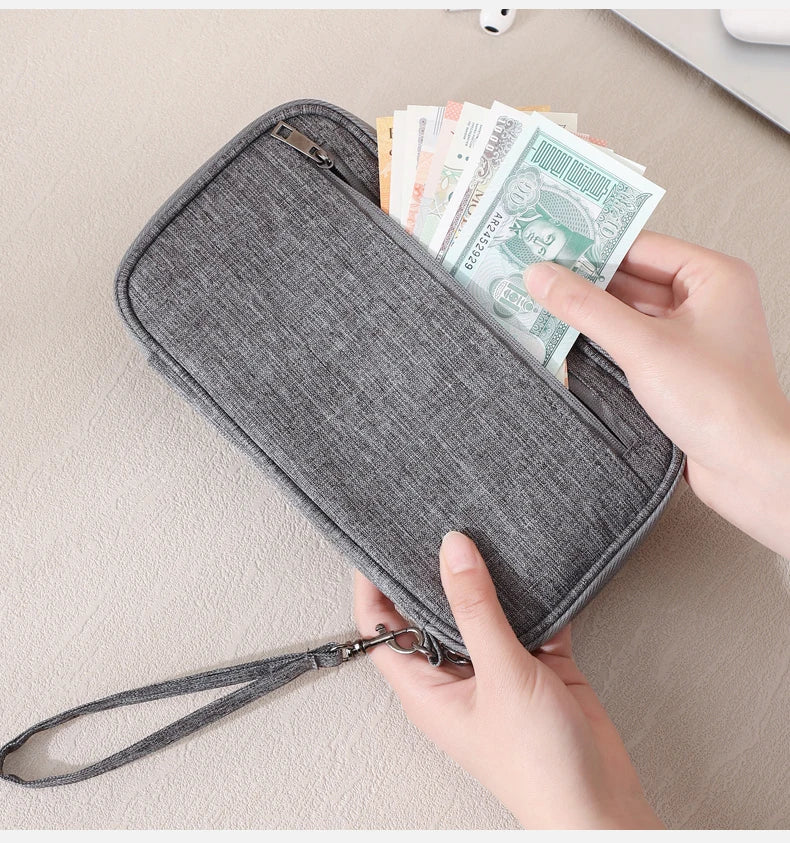 Una mano abre una cartera de pasaporte con bloqueo RFID gris para revelar efectivo y documentos.