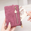 A hand holds a mauve retro PU leather double fold wallet with a gold zipper pull.
