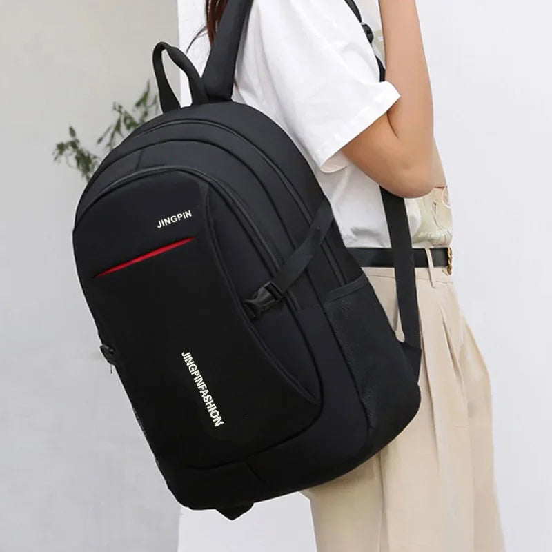 A black Jingpin backpack is shown being carried by a person, featuring red stitching and a beige skirt.