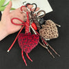 A collection of leopard print plush love pendants and keychains with various colored cords and beads.