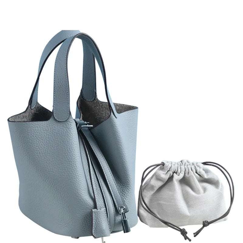 Helles blaues Leder-Bucket-Bag mit Reißverschluss und passender Schnurtasche.
