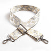 A beige and gray jacquard patterned adjustable crossbody bag strap with metal hardware.