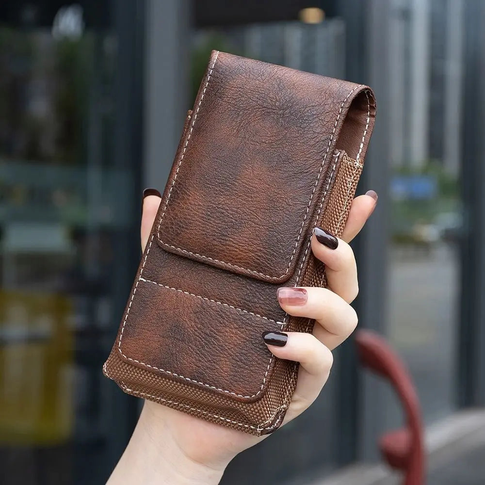 A brown PU leather phone waist pouch with a belt clip is held by a hand.