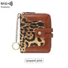 A brown leather bifold wallet with a leopard print cover and a metal chain attached.