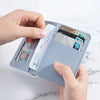 A hand is holding a light blue card wallet displaying several credit cards and an ID card.