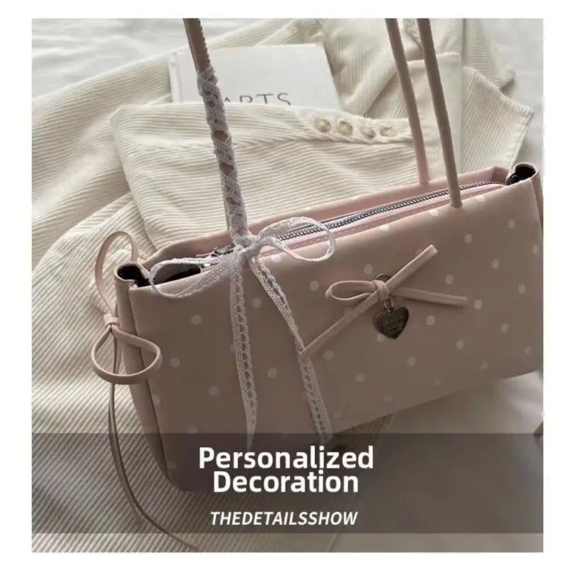 Lichtrosa Retro-Polka-Dot-Schultertasche mit weißem geflochtenem Riemen und goldener Hardware auf weißem Stoff.