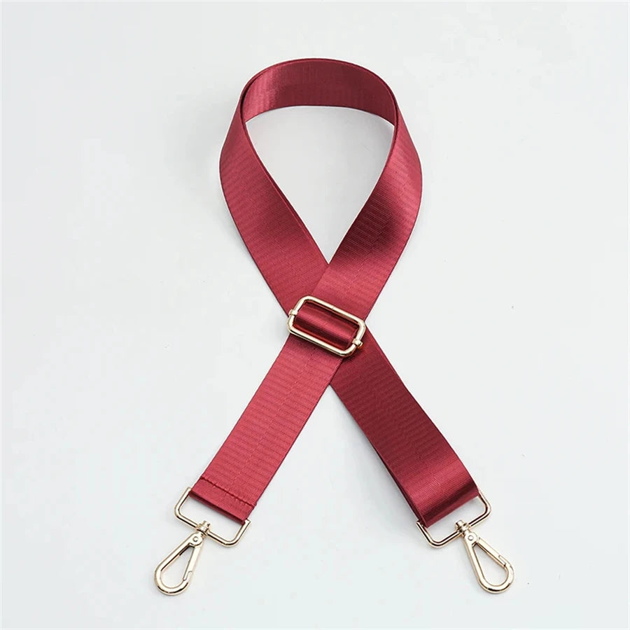 A maroon adjustable nylon shoulder strap in an 'X' shape with metal clasps.