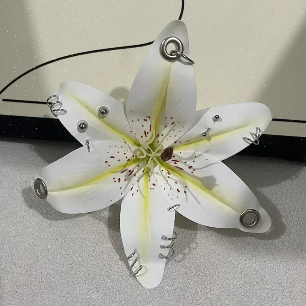 A realistic white orchid flower shaped keychain with yellow accents and metal findings.