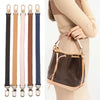 A brown leather shoulder strap is shown against a light beige sweater, highlighting its texture and length.