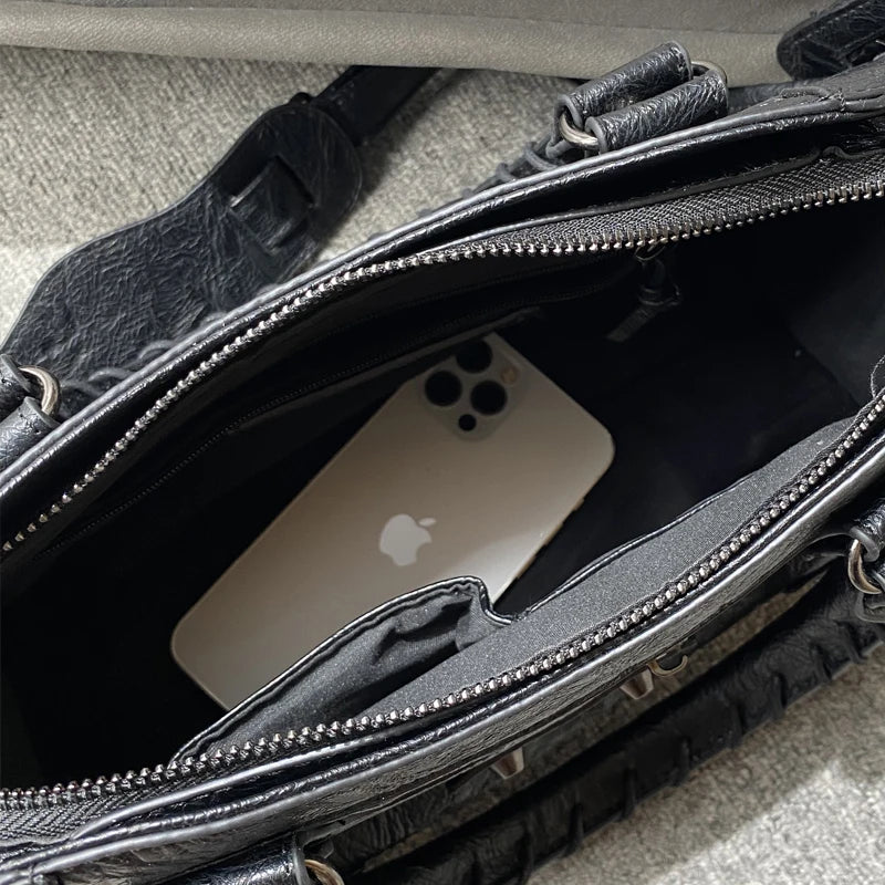 A black soft PU leather shoulder tote bag with a zippered interior showing an Apple phone.