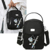 Sac bandoulière floral noir avec quincaillerie argentée tenu par une main