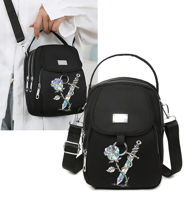 Schwarze Blumen-Crossbody-Tasche mit silberner Hardware, die von einer Hand gehalten wird
