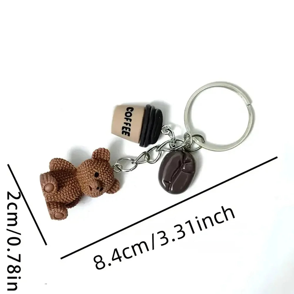 A brown teddy bear pendant keychain with a coffee tag and a leather charm.