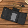 A black men's genuine leather trifold wallet with a detachable gold-toned chain resting on a wooden surface.